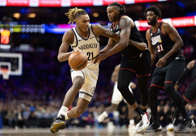 Dec 23, 2025; Philadelphia, Pennsylvania, USA; Brooklyn Nets forward Noah Clowney (21) dribbles against Philadelphia 76ers forward Jabari Walker (33) during the first quarter at Xfinity Mobile Arena. Mandatory Credit: Bill Streicher-Imagn Images