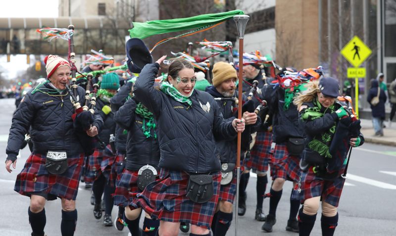ROC City Guardians Pipes and Drums battle the wind as they turn from East Ave onto E Main Street during the cold and windy Tops St. Patrick’s Day Parade in downtown Rochester Saturday, March 14, 2026.