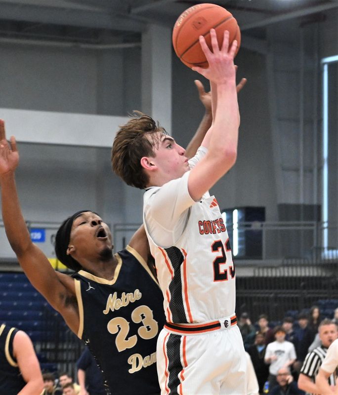 Cooperstown Hawkeye Miles Nelen goes up for a shot with Scoon Jenkins (left) defending for Notre Dame of Elmira during a Class C regional playoff game Sunday at SRC Arena in Syracuse, New York.