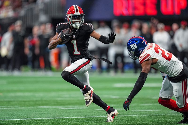 Dec 22, 2024; Atlanta, Georgia, USA; Atlanta Falcons wide receiver Darnell Mooney (1) runs against New York Giants safety Jason Pinnock (27) after a catch during the first half at Mercedes-Benz Stadium. Mandatory Credit: Dale Zanine-Imagn Images