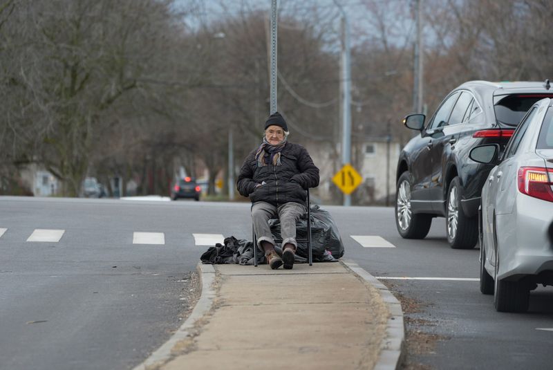 Homelessness is an issue in Rochester and its suburbs. A person sits on the corner of Exchange Boulevard and Ford Street with their belongings around them on March 16, 2026.