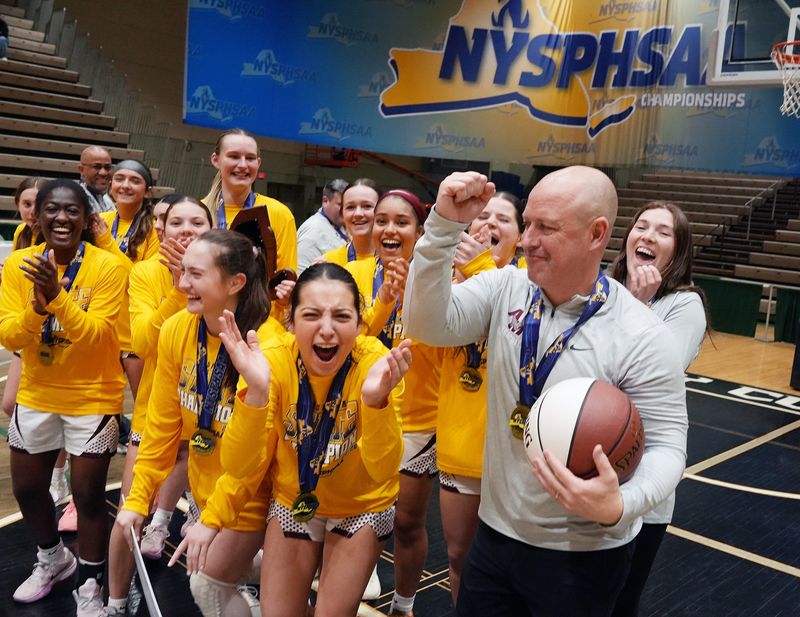 Albertus Magnus coach Pat Buckley celebrates with his team after defeating Aquinas in state girls basketball championship game at Hudson Valley Community College in Troy March 20, 2026.