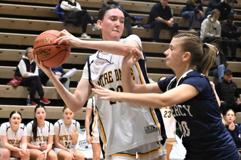 Ella Trinkaus looks for a passing lane along the baseline during the Notre Dame Jugglers' Class A state semifinal playoff game against Our Lady of Mercy of Rochester Saturday. The Jugglers play for a state championship Sunday morning against Tappan Zee back at Hudson Valley Community College.