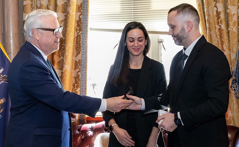 State Sen. Tom O'Mara, left, congratulates Chemung County sheriff's investigator Michael Theetge after Theetge, seriously injured in a 2024 incident, was presented with a Senate Commendation Award in Albany on March 25, 2026. Looking on is Theetge's wife Patrice.