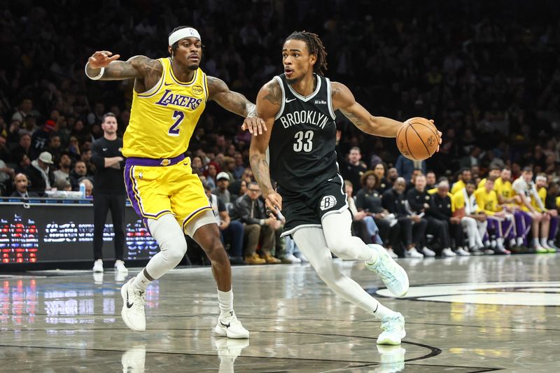 Feb 3, 2026; Brooklyn, New York, USA; Brooklyn Nets center Nic Claxton (33) drives past Los Angeles Lakers forward Jarred Vanderbilt (2) in the first quarter at Barclays Center. Mandatory Credit: Wendell Cruz-Imagn Images