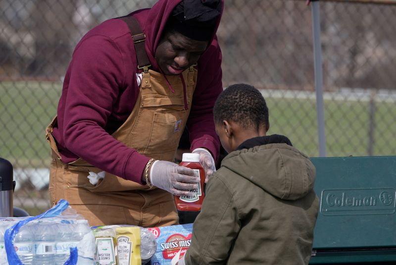 Devon Reynolds, owner of Brothers & Sisters Unisex Salon, puts away the ketchup after putting some on the boy’s hot dog at the Easter Egg Hunt held at Edgerton Park in Rochester on March 29, 2026. The event was sponsored by Barbers from Dream Cuts, Brothers & Sisters Unisex Salon, Sweet Ida Mae’s Pantry, and Tenth Ward Tigers Youth Sports. Reynolds founded and operates Sweet Ida Mae’s Pantry.