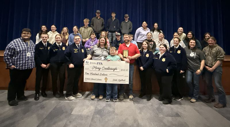 Marcus Whitman agriculture teacher and school FFA adviser Mary Coolbaugh, center, with her family, receives a state Golden Owl Award during a surprise ceremony at the high school on March 26.