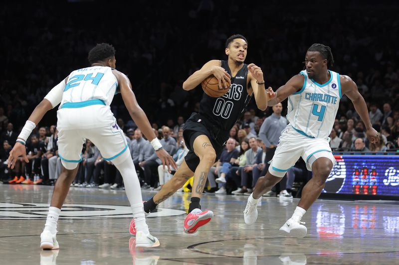 Mar 31, 2026; Brooklyn, New York, USA; Brooklyn Nets forward Josh Minott (00) drives to the basket against Charlotte Hornets forward Brandon Miller (24) and guard Sion James (4) during the first quarter at Barclays Center. Mandatory Credit: Brad Penner-Imagn Images