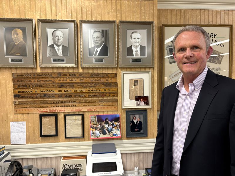 Mike Davidson stands by photographs of four generations of owners of Davidson's Furniture Store in Hornell. They are Alexander Davidson, Alexander P. Davidson, Adam T. Davidson and Mike Davidson, the current owner. Davidson's Furniture Store was established in 1876.