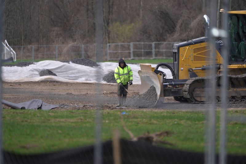 A roll of material was spread over the ground with gravel being placed over it in an area of the athletic field at Brighton High School in Brighton on April 6, 2026.
