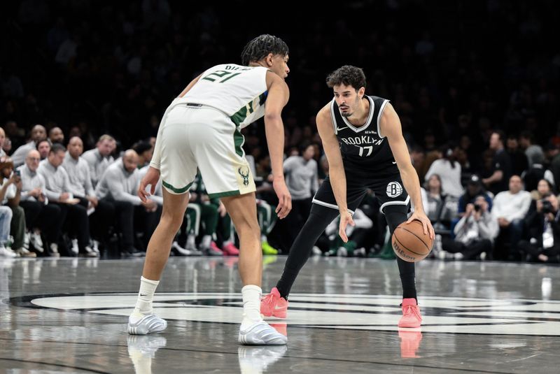 Apr 7, 2026; Brooklyn, New York, USA; Brooklyn Nets guard Ben Saraf (77) sets a play while defended by Milwaukee Bucks forward Ousmane Dieng (21) during the first half at Barclays Center. Mandatory Credit: John Jones-Imagn Images