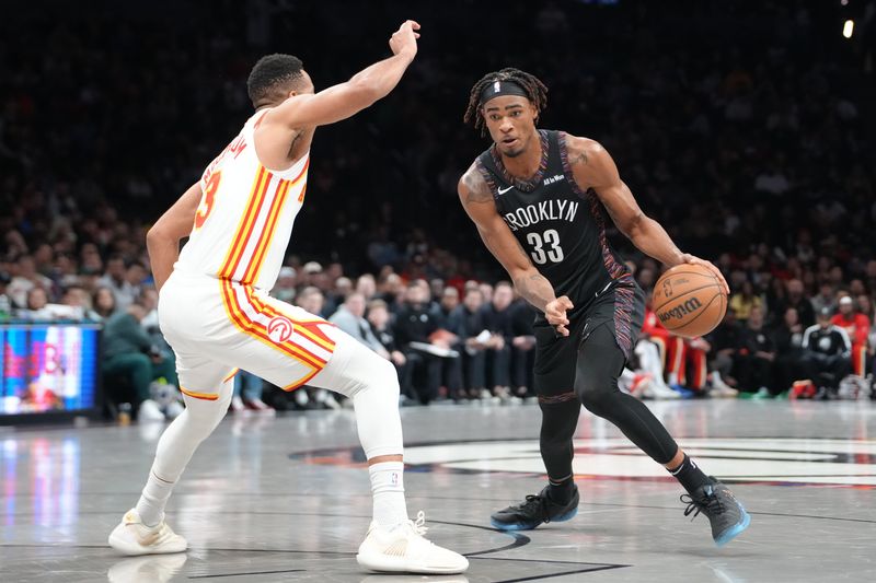 Apr 3, 2026; Brooklyn, New York, USA; Brooklyn Nets center Nic Claxton (33) dribbles the ball against Atlanta Hawks guard CJ McCollum (3) during the first half at Barclays Center. Mandatory Credit: Gregory Fisher-Imagn Images