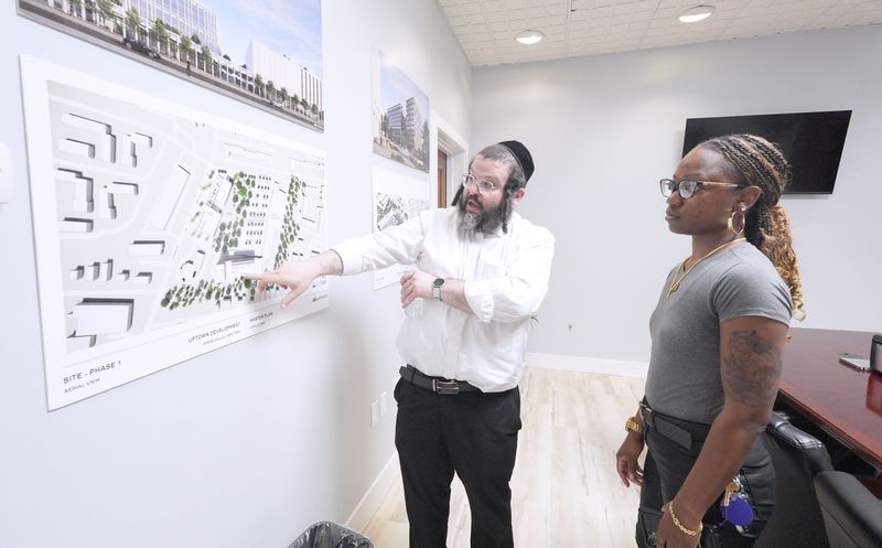 Spring Valley Planning Board Chair Yossi Reich shows development plans to Sabrina Charles-Pierre, a village resident and East Ramapo school board trustee during Spring Valley Mayor Schenley Vital's state of the village address at village hall April 14, 2026.