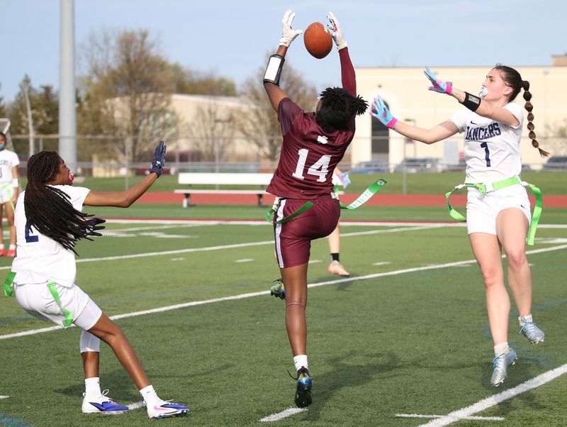 Aquinas wide receiver Bles'ng Muhammad pulls down a touchdown reception between Eastridge’s Qa'Mariona Greene and Trinity Platania in the first quarter during their Section V flag football game Wednesday, April 15, 2026 at Aquinas Institute.