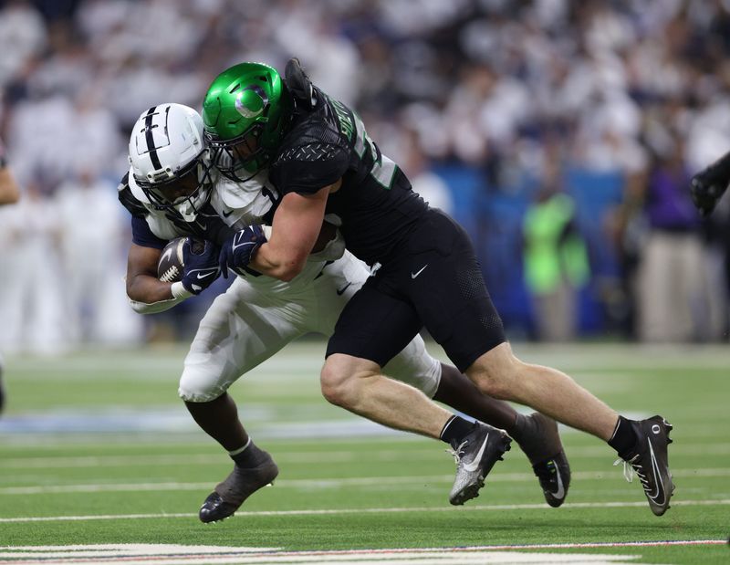 Penn State Nittany Lions running back Nicholas Singleton (10) is tackled by Oregon Ducks linebacker Bryce Boettcher (28) during the second quarter in the 2024 Big Ten Championship game at Lucas Oil Stadium.