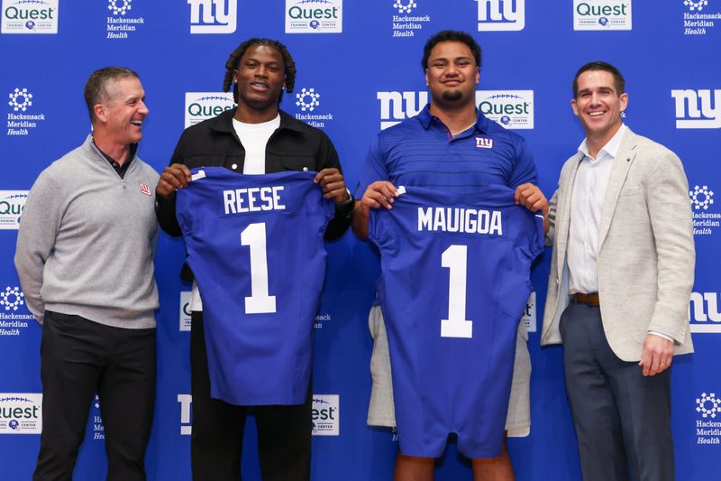 Apr 24, 2026; East Rutherford, NJ, USA; New York Giants draft picks Arvell Reese and Francis Mauigoa, Head Coach John Harbaugh (left) and General Manager Joe Schoen (right) pose for a photo during the introductory press conference at Quest Diagnostics Training Center. Mandatory Credit: Tom Horak-Imagn Images