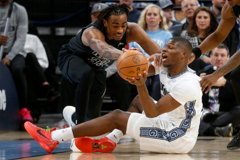 Jan 11, 2026; Memphis, Tennessee, USA; Brooklyn Nets center Nic Claxton (33) and Memphis Grizzlies forward Cedric Coward (23) battle for a loose ball during the first quarter at FedExForum. Mandatory Credit: Petre Thomas-Imagn Images