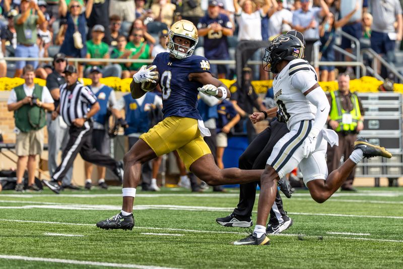 Sep 20, 2025; South Bend, Indiana, USA; Notre Dame Fighting Irish wide receiver Malachi Fields (0) scores a touchdown as Purdue Boilermakers defensive back Tony Grimes (0) defends during the first half at Notre Dame Stadium. Mandatory Credit: Michael Caterina-Imagn Images