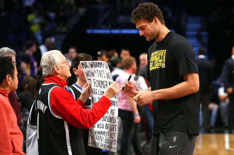 Feb 2, 2018; Brooklyn, NY, USA; Los Angeles Lakers center Brook Lopez (11) signs an autograph for Nets fan Mr. Whammy during warms up before a game against the Brooklyn Nets at Barclays Center. Mandatory Credit: Brad Penner-USA TODAY Sports