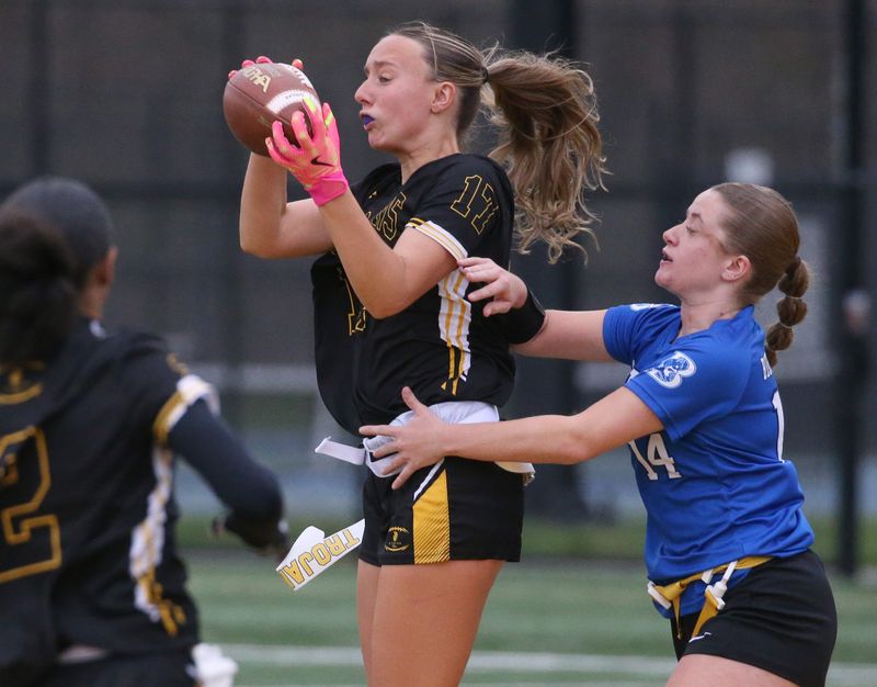 Athena’s Lauren Grasley pulls in a pass across the middle for a first down ahead of pressure from Batavia’s Ava Darling during their Section V flag football game Tuesday, April 28, 2026 at Greece Athena High School.