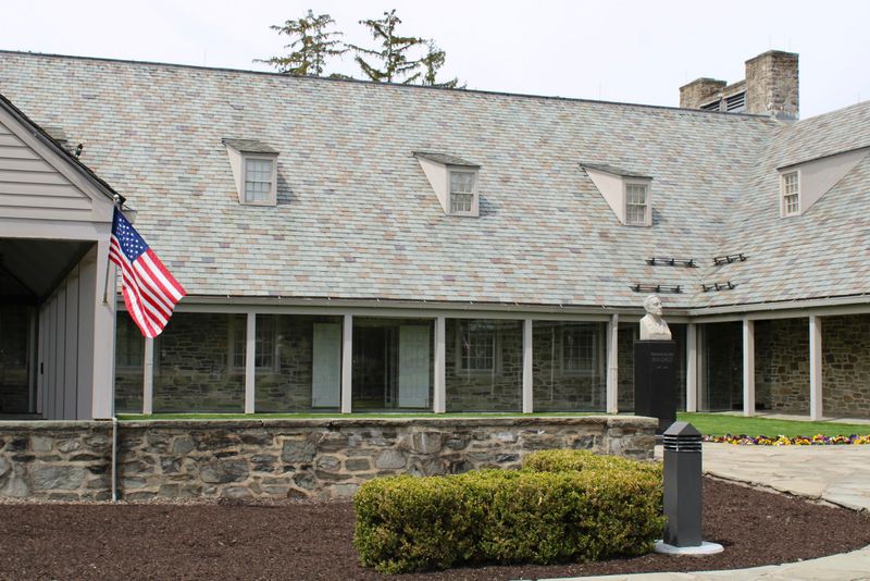 A flag waving and the bust of Franklin D. Roosevelt outside the Franklin D. Roosevelt Presidential Library & Museum at 4079 Albany Post Road in Hyde Park on April 28, 2026.