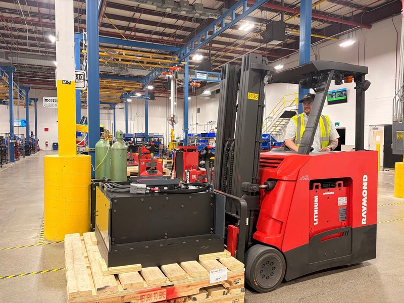 A Raymond battery-powered vehicle transporting one of the company's lithium-ion batteries.