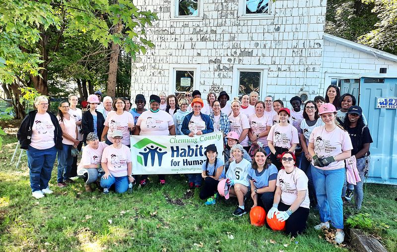 Volunteers pose for photos during a "Women Build" event sponsored by Chemung County Habitat for Humanity.
