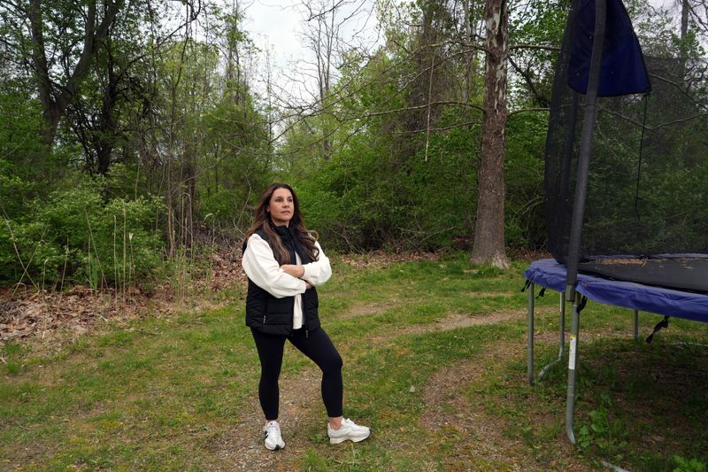 Homeowner Jaime Lee on May 6, 2026 stands in her Hopewell Junction backyard near her property line where a development company has purchased the land. Neighbors have been on guard since 2024 to fight plans for two large warehouses in the sprawling woods near their homes in the Town of East Fishkill. But new plans have surfaced to instead build a giant data center, bigger than any other in New York with the intent to use 1,000 megawatts of electricity.