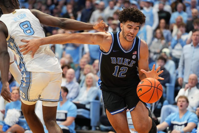Feb 7, 2026; Chapel Hill, North Carolina, USA; Duke Blue Devils forward Cameron Boozer (12) with the ball as North Carolina Tar Heels forward Caleb Wilson (8) defends in the first half at Dean E. Smith Center. Mandatory Credit: Bob Donnan-Imagn Images