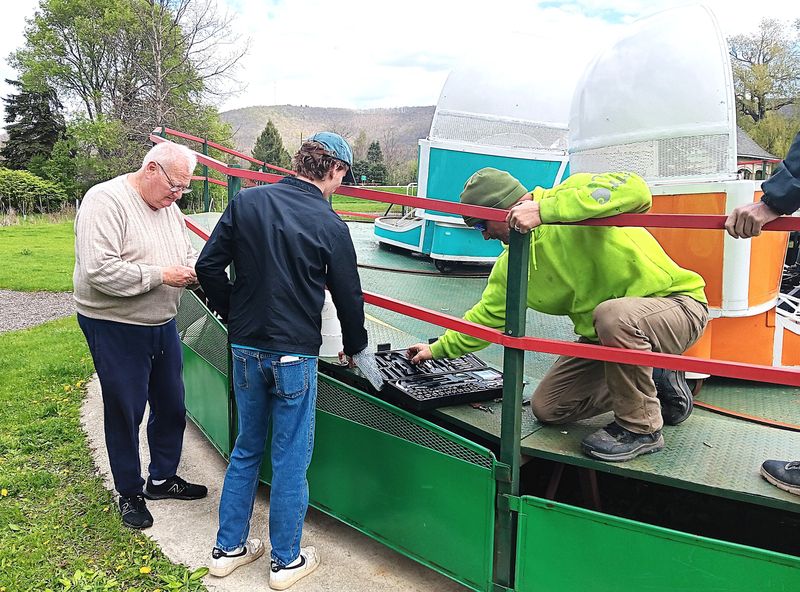 Volunteers Walt Kowalski, left, Tanner Vonderchek and Chris Moore getting the Tilt-a-Whirl up and running for the 2026 season at Eldridge Park in Elmira, which will open its rides and attractions Friday, May 22.