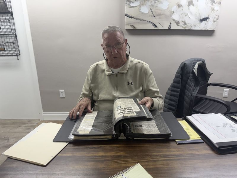 Town of Corning Historian Ron Hodge, who will retire at the end of the month, looks through one of the books at the historian's office.