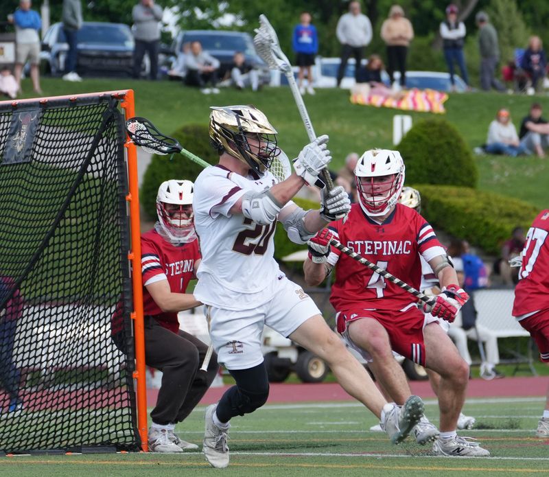Iona Prep’s Tim Plunkett (20) passes to a teammate against Stepinac during CHSAA lacrosse playoff action at Iona Prep in New Rochelle May 14, 2026. Iona Prep won the game 16-7.
