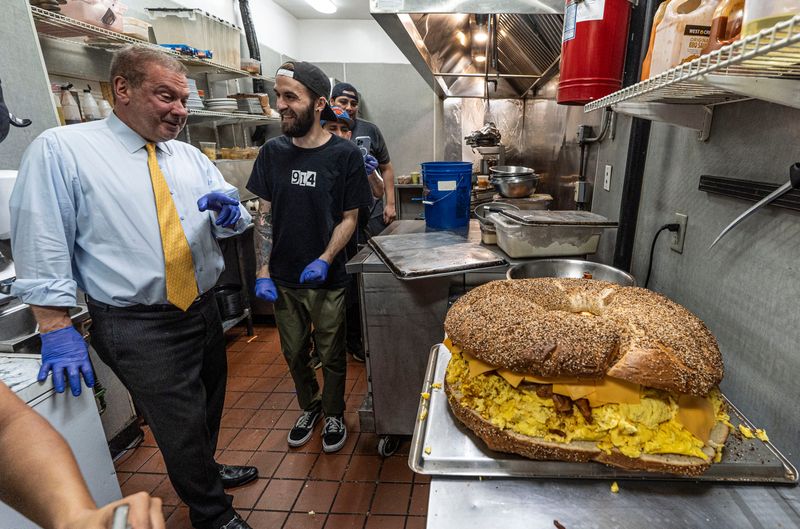 Yonkers Mayor Mike Spano and A.J. Chiarella, owner of the 914 Collective, laugh after completing a huge bacon, egg, and cheese bagel at the Yonkers Brewing Company May 17, 2026. The 914 Collective, Yonkers Brewing Company, and the Brooklyn Bagel & Coffee Company partnered to create New York’s largest bacon, egg, and cheese sandwich. The finished 20 inch bagel, weighed in at about 20 pounds and included 150 eggs. The record breaking bagel was one of the highlights of Yonkers Arts Weekend.