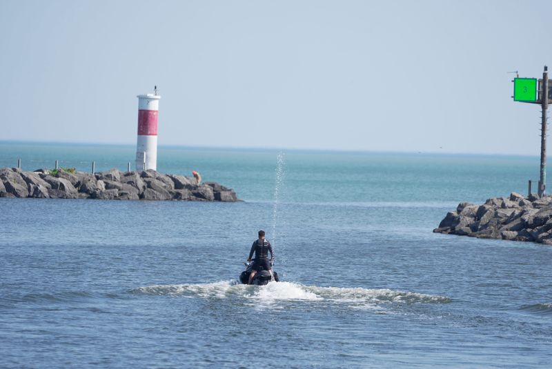 A personal watercraft heads out onto Lake Ontario passing through the Irondequoit Bay outlet in Irondequoit on May 18, 2026. Temperatures are expected to reach near 90 degrees over today and tomorrow.