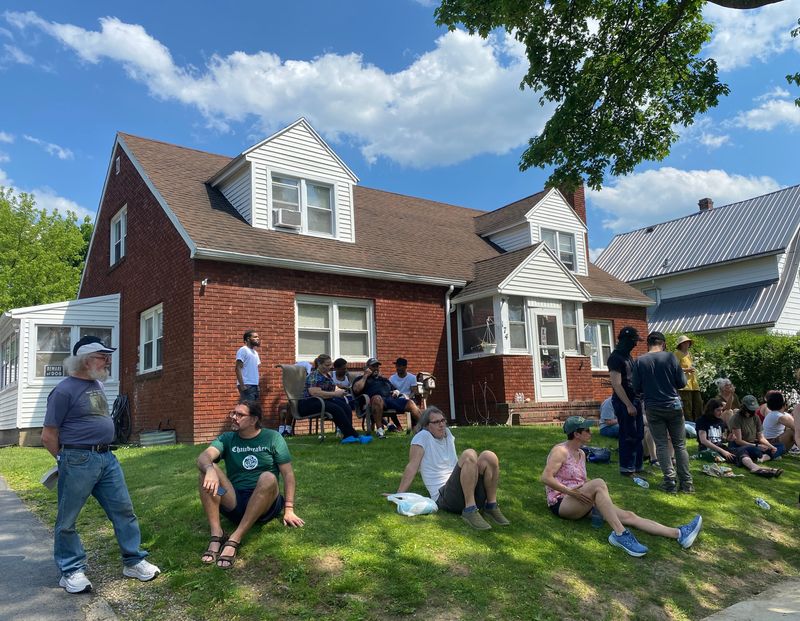 Dozens of residents sat watch on the lawn of a Newcomb Street home while unmarked SUVs ― suspected to be ICE vehicles ― idled in the neighborhood on May 18, 2026.