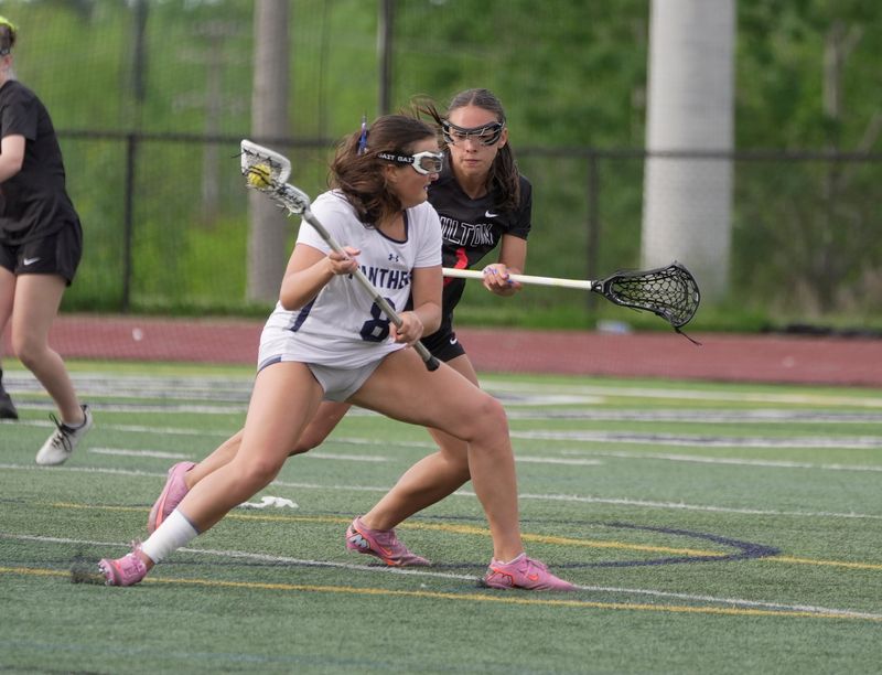 Pittsford’s Morgan Wilson drives towards the net while Hilton’s Ava Tata presses her during their quarterfinal playoff game at Pittsford Sutherland High School in Pittsford on May 22, 2026.