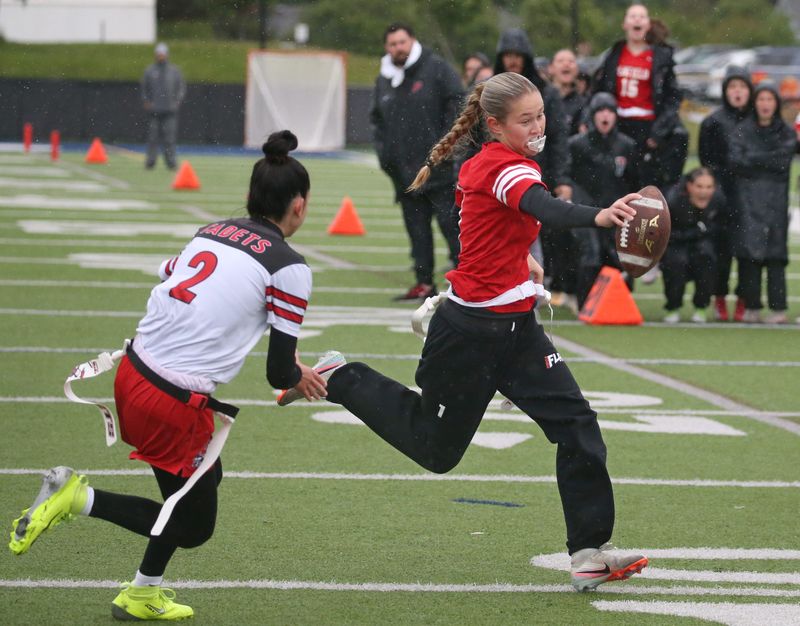 Penfield quarterback Sophia Puccia reaches over the goal line to score ahead of Hilton’s Alina Gruttadauria, putting Penfield up 12-0 in the second quarter during their Section V flag football sectionals Class A final Saturday, May 23, 2026 at Gates Chili High School.