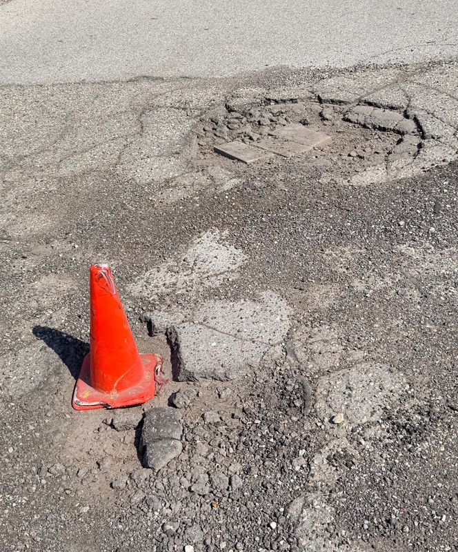 An orange traffic cone marks a pothole in the Birchwood Mall parking lot on May 27, 2026 in Fort Gratiot Township.