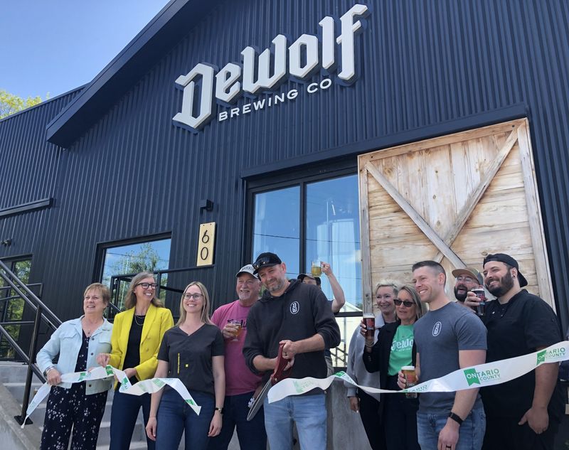 Village of Victor and Ontario County Chamber of Commerce officials join Justin and Mari DeWolf (center), owners of DeWolf Brewing Co., for a ribbon-cutting ceremony.