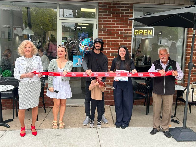 Grace Monaco of Greater Utica Chamber of Commerce, with some regular patrons, join Erika and Bryce Lamberto as they help five-year-old son Beau cut the ribbon to celebrate 5 years in business in Village of New Hartford, where Calabria Coffee has become a 'go-to' place to gather. Provided by Greater Utica Chamber of Commerce
