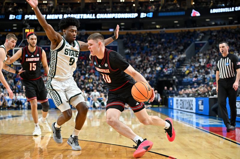 Mar 21, 2026; Buffalo, NY, USA; Louisville Cardinals guard Isaac McKneely (10) drives the ball while defended by Michigan State Spartans guard Trey Fort (9) in the second half during a second round game of the men's 2026 NCAA Tournament at Keybank Center. Mandatory Credit: Mark Konezny-Imagn Images