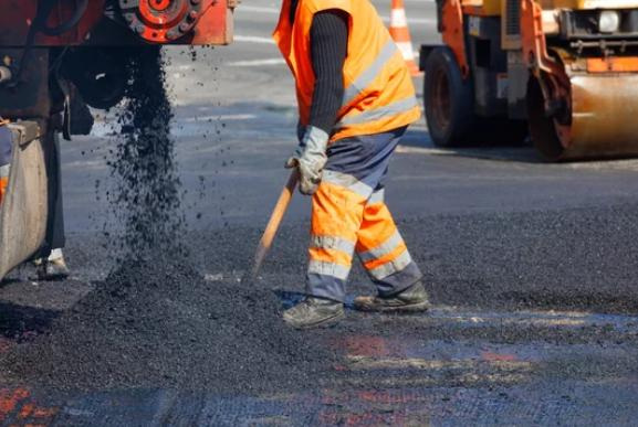 Construction workers paving a road