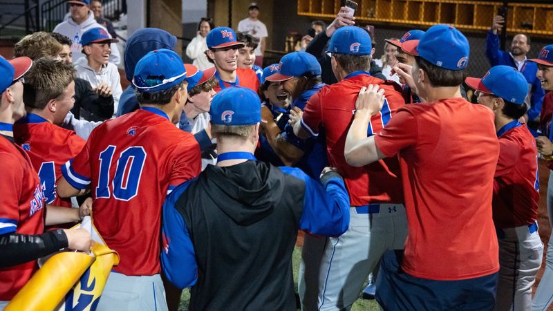 New Hartford baseball players celebrate with coach Kevin Green after defeating Cortland 12-0 in the Section III Class A final at Onondaga Community College in Syracuse Monday.