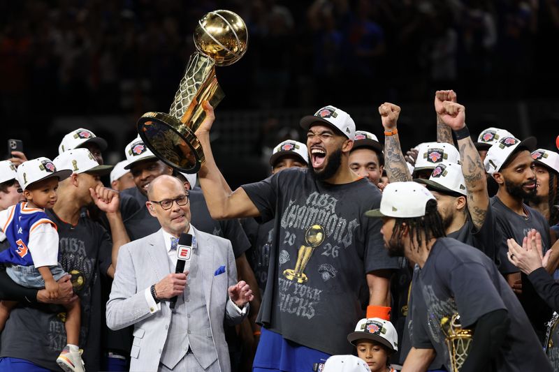 Jun 13, 2026; San Antonio, Texas, USA; New York Knicks center Karl-Anthony Towns (R) celebrates with the Larry O'Brien championship trophy while being interviewed by broadcaster Ernie Johnson (L) after game five of the 2026 NBA Finals against the San Antonio Spurs at Frost Bank Center. Mandatory Credit: Geoff Burke-Imagn Images
