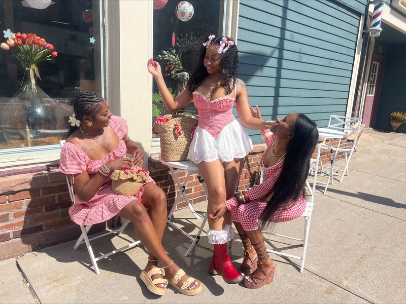 Rani Hayes (standing), Aaliyah Blanks and Marnique Alexander (sitting, left to right) traveled from Buffalo to attend the Albion Strawberry Festival in their matching strawberry-themed outfits.