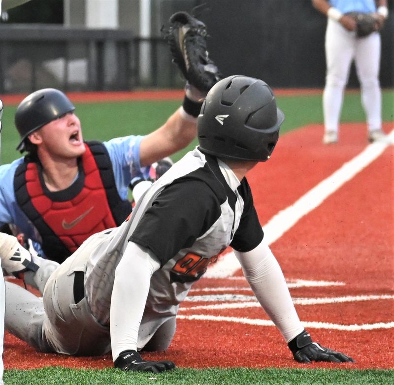 Utica Blue Sox catcher Andrew Johnston holds up his glove to show the umpire the ball after tagging Oneonta Outlaw Jack Lockwood out at the plate as the potential tying run in the seventh inning Thursday at Murnane Field.
