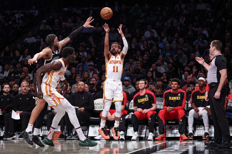 Mar 16, 2025; Brooklyn, New York, USA; Atlanta Hawks guard Trae Young (11) makes a three point basket during the first quarter against the Brooklyn Nets at Barclays Center. Mandatory Credit: Vincent Carchietta-Imagn Images