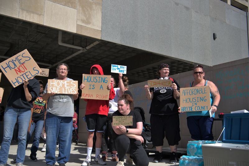 Demonstrators held signs along the sidewalk outside the Broome County Office Building on June 23, 2026 calling on the community and elected officials to do better for the residents of Broome County in response to the fatal Knights Inn fire.