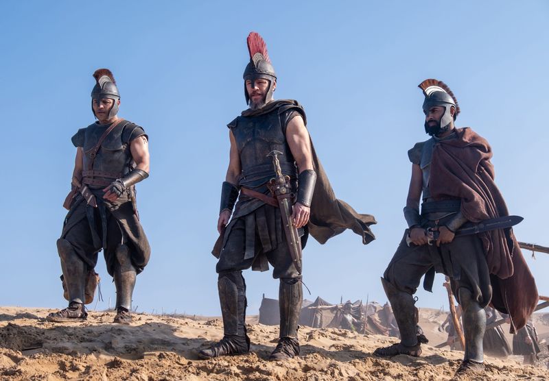 Center L to R: Jimmy Gonzales is Cepheus, Matt Damon is Odysseus and Himesh Patel is Eurylochus in THE ODYSSEY, written, produced, and directed by Christopher Nolan.
