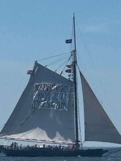 The Hudson River Sloop Clearwater on Saturday, July 4, 2026, when it was removed by the U.S. Coast Guard from the Sail 4th 250 Parade of Sail because of a pair of banners deemed too political. This one read INDIGENOUS RIGHTS RACIAL JUSTICE CLIMATE SOLUTIONS. The other read SAVE THE CLEAN WATER ACT.